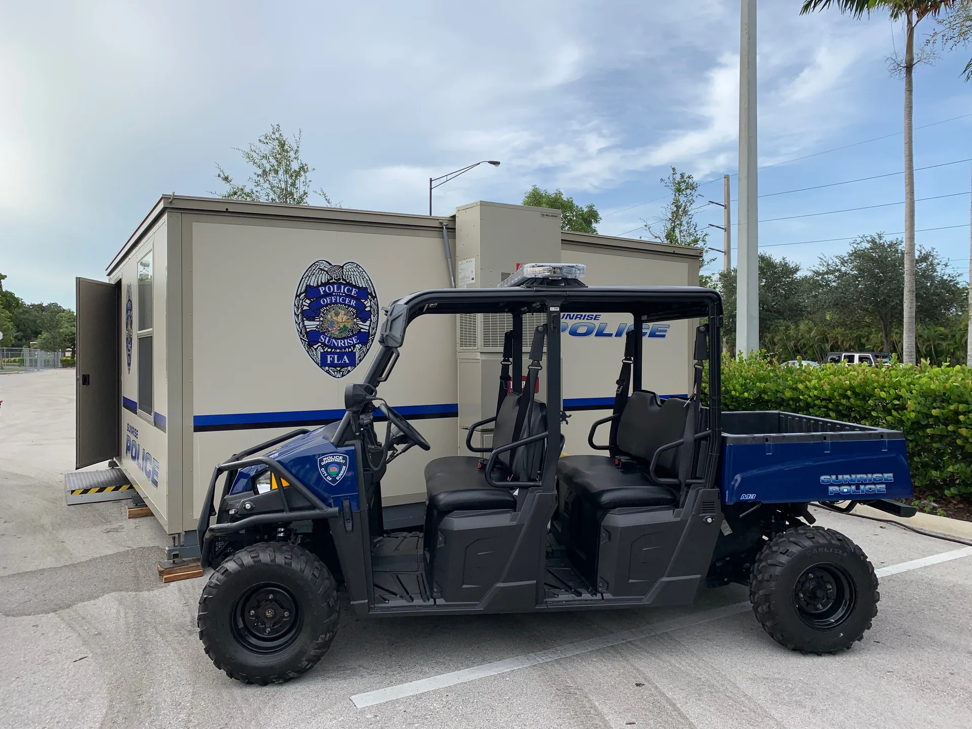 Sunrise Police-branded FORTS unit beside a police utility vehicle.